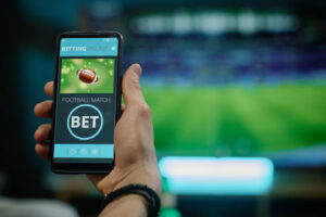 Close-up of a smartphone displaying a football betting app with a “Bet” button, symbolizing online sports gambling – 99exch Review.